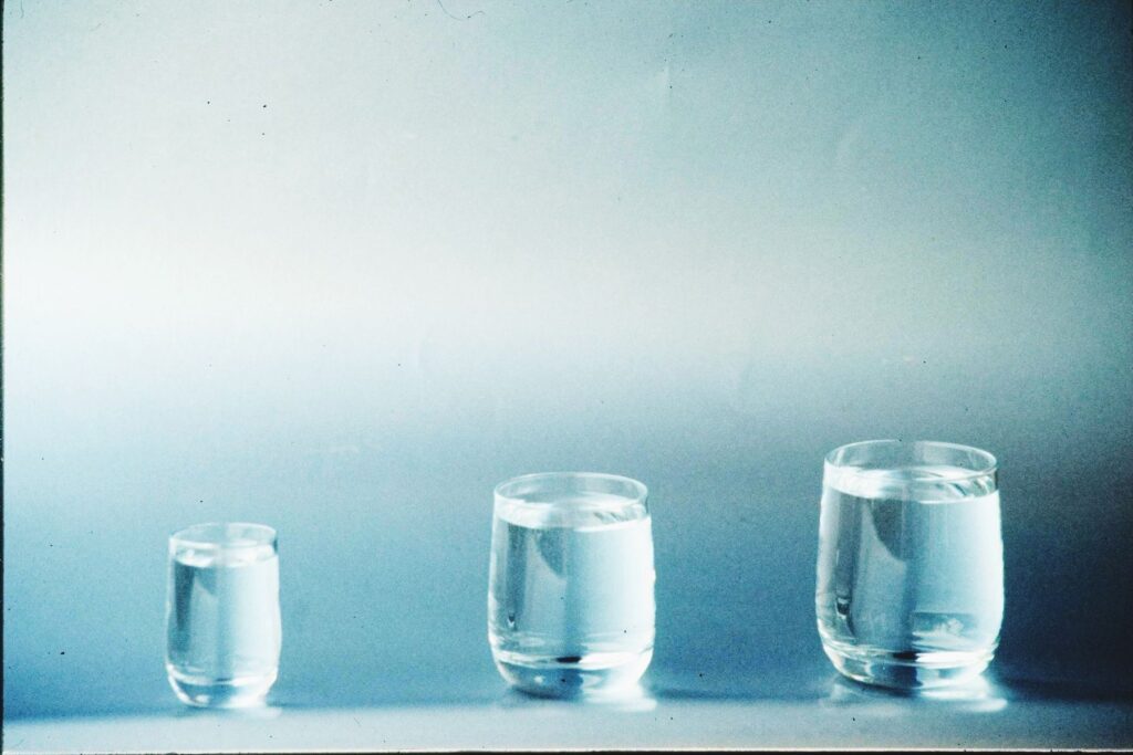 Three glasses of water on a blue background
