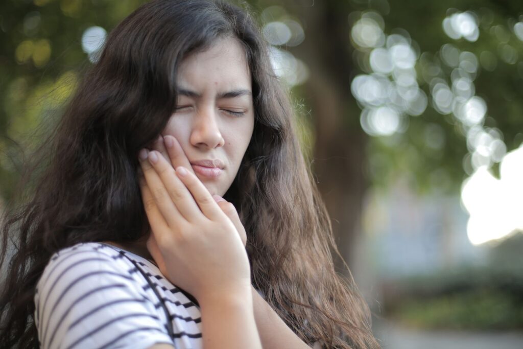 Woman holding her cheek with a look of tooth pain